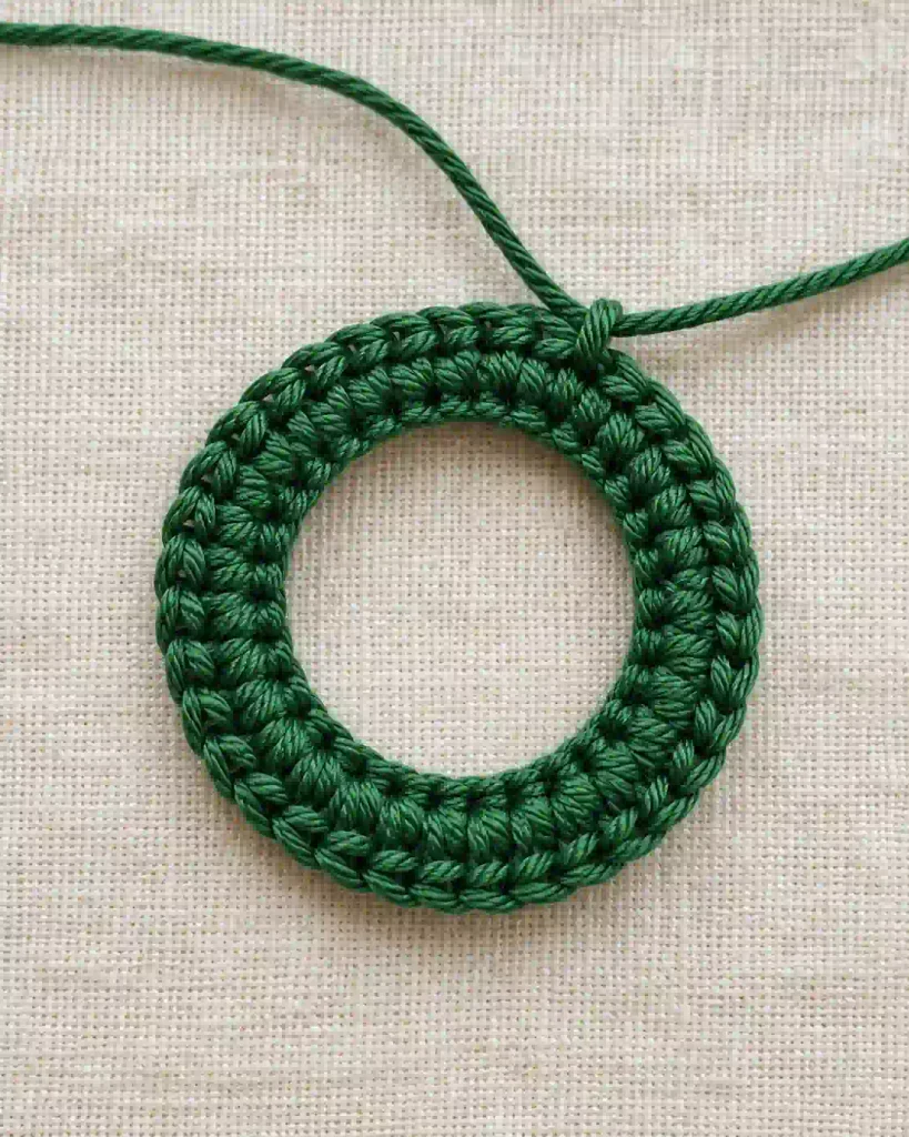 Crochet Mini Christmas Wreath Ornament Pattern showing the green foundation ring with 36 single crochet stitches.