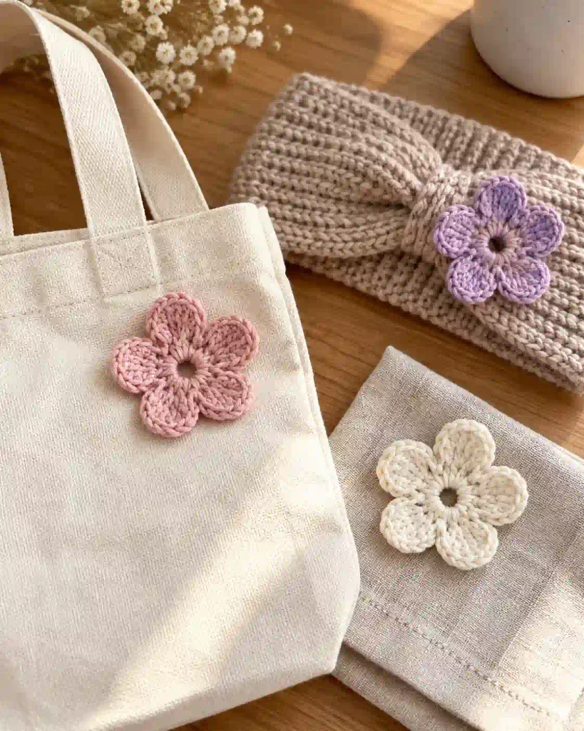 Handmade five petal crochet flowers decorating a cotton tote bag and a headband