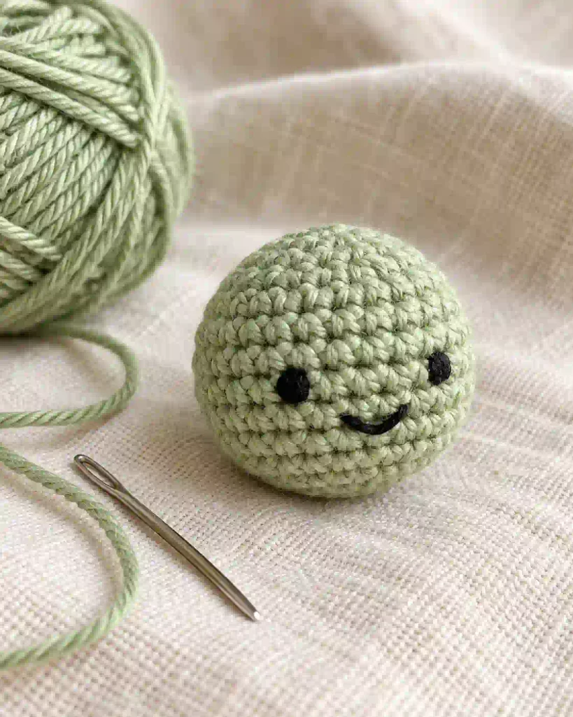 Mini Crochet Turtle Pattern showing a light green amigurumi turtle head wit