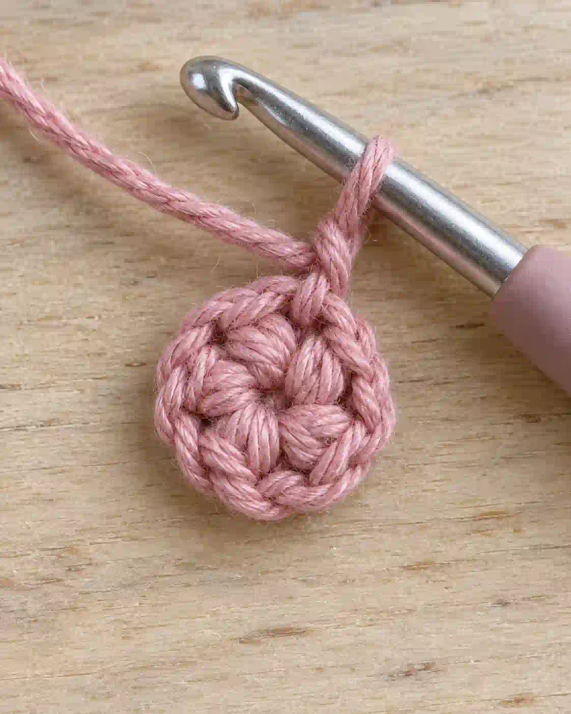 Small crochet flower center made with five single crochet stitches in a magic ring